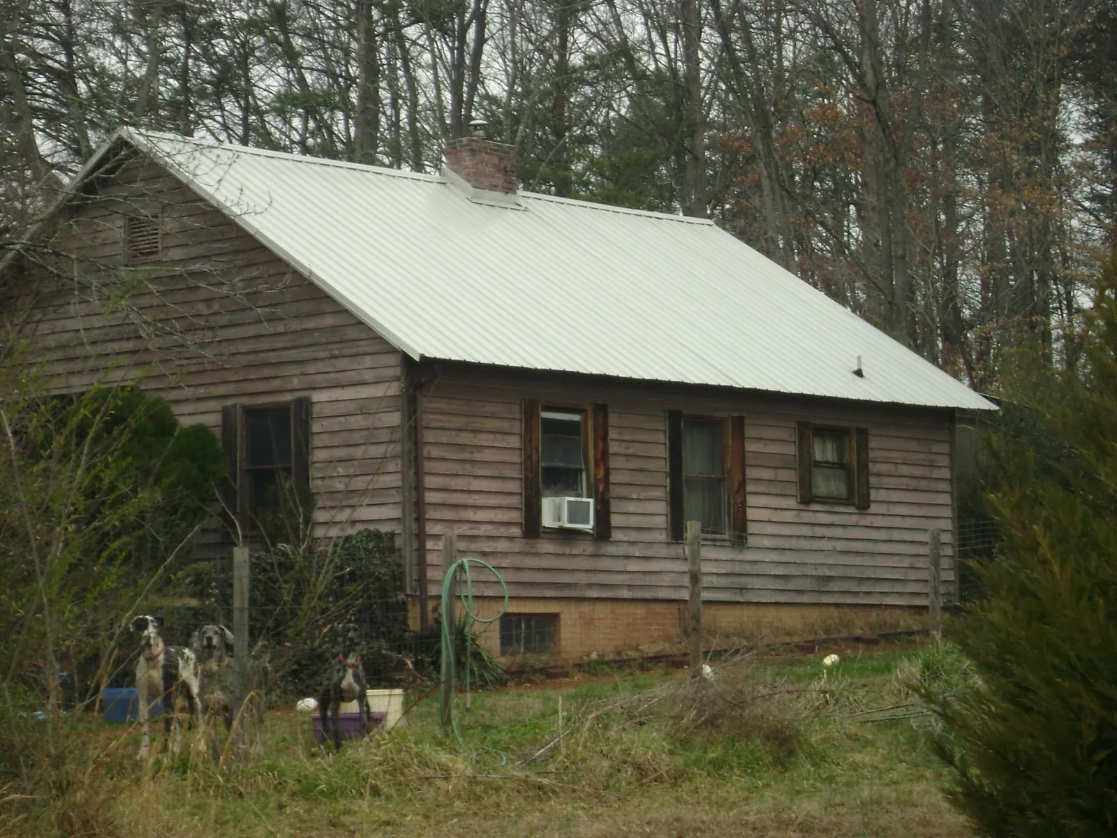 White metal roof on an old wood sided farmhouse, from a Asphalt Shingle Roof Repair job in Hutchinson